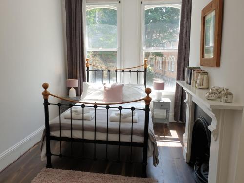 ein Schlafzimmer mit einem Bett in einem Zimmer mit Fenstern in der Unterkunft St Martins View in York