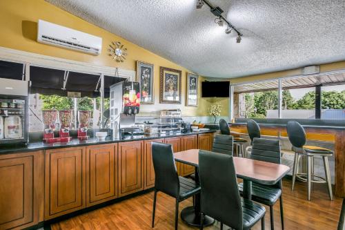 a kitchen with a bar with chairs and a table at Scottish Inns Harrisburg-Hershey South in New Cumberland