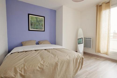 a bedroom with a bed and a surfboard in it at 70 m2 avec Balcons et Parking in Lille