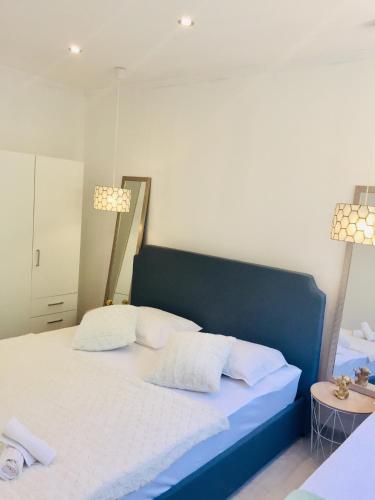 a bedroom with a blue bed with two white pillows at Apartments Juraković in Živogošće