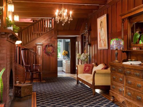 a living room with wood paneling and a staircase at Abbeymoore Manor in Victoria