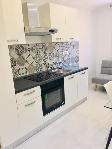 a kitchen with a sink and a stove top oven at Apartments Juraković in Živogošće