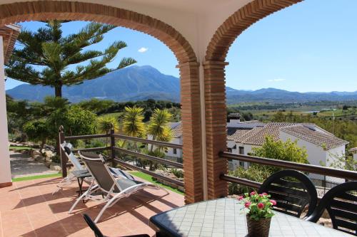 eine Terrasse mit Stühlen und einem Tisch auf dem Balkon in der Unterkunft Alojamientos Huetor in Viñuela