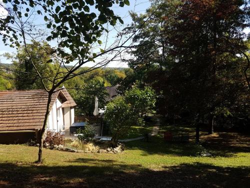 Ambition Zen Presles في Presles: منزل أبيض صغير في ساحة بها أشجار