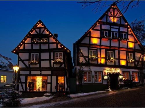 two black and white buildings with lights on them at Hotelbetriebe Güldenhaupt GmbH in Arnsberg