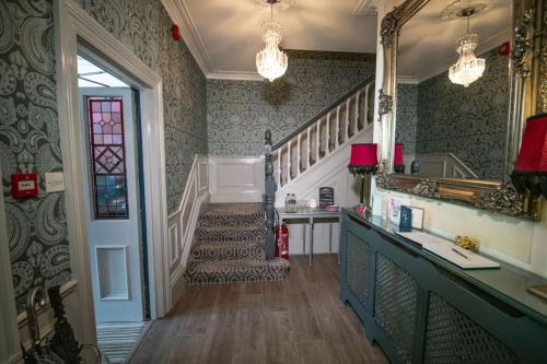 um corredor com uma escada e um lavatório numa casa em Amarillo Guesthouse em Bournemouth