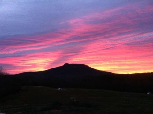 un coucher de soleil avec une montagne en arrière-plan dans l'établissement A Mighty Oak B&B, à Pilot Mountain