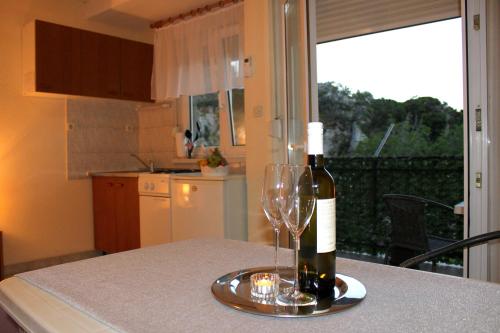 a bottle of wine and two glasses on a table at Apartments Nature in Omiš