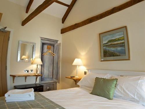 a bedroom with a white bed and two lamps at The Anchor Inn in Ivybridge