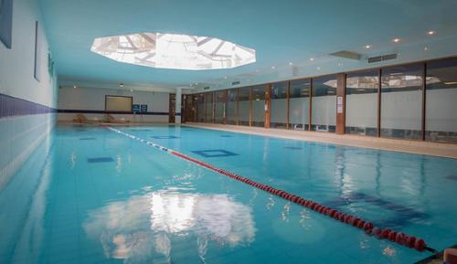 uma grande piscina com água azul num edifício em Talbot Hotel Carlow em Carlow