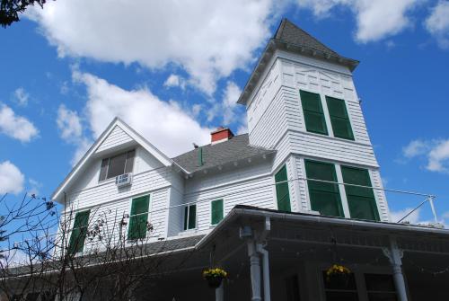 una casa bianca con una torre sopra di Anne's Washington Inn a Saratoga Springs