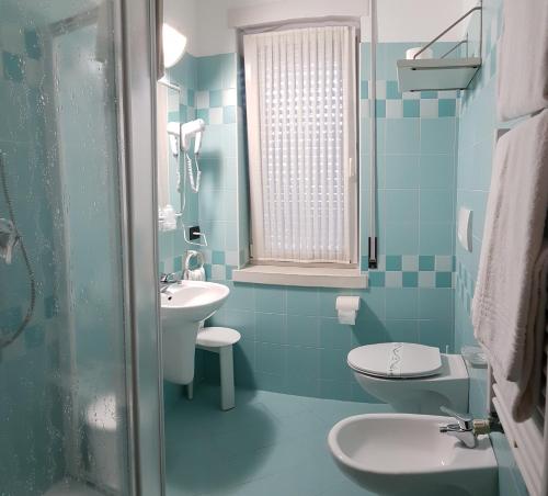 une salle de bain bleue avec un lavabo et des toilettes dans l'établissement Locanda Castagna, à Arzignano