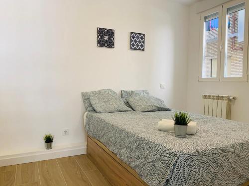 a white bedroom with a bed and two windows at Moncloa-Arguelles nuevos pisos in Madrid