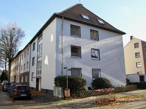 a white building with a black roof on a street at Apartmenthaus in der Arnoldstraße in Bochum