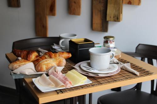 una mesa con una bandeja de pan, pastas y tazas en Casa Do Campo, en Peniche