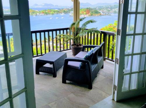a balcony with chairs and a table and a plant at Ocean Crest Villas in Castries