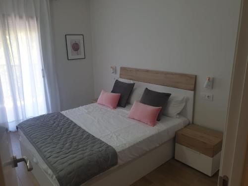 a bedroom with a bed with pink and black pillows at Maxx Apartamento in Salou
