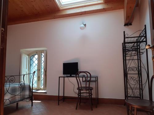 a room with chairs and a desk with a television at Contrada Zerbate in Aci SantʼAntonio