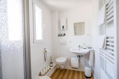 Baño blanco con lavabo y aseo en Pension Herheinspaziert, en Bad Breisig