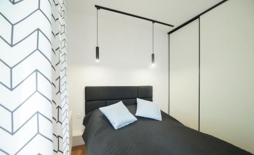 sypialnia z łóżkiem z czarnym zagłówkiem w obiekcie Villa Wenecja Apartament ALBERO w Poznaniu