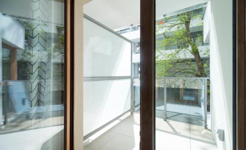 szklanymi drzwiami z widokiem na budynek w obiekcie Villa Wenecja Apartament ALBERO w Poznaniu