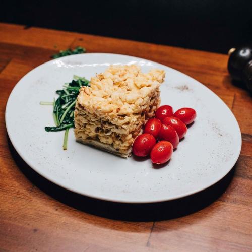 a white plate with a piece of cake and red berries at Rooster Suites in Athens