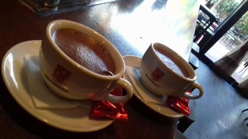 two cups of coffee on plates on a table at Rooster Suites in Athens