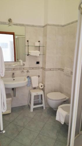 a bathroom with a sink toilet and a mirror at Hotel Palace in Levanto