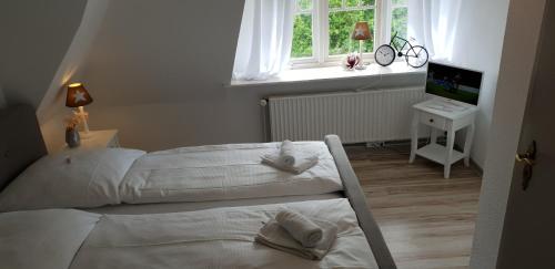 a bedroom with two white beds in front of a window at Kampen Bergente in Kampen