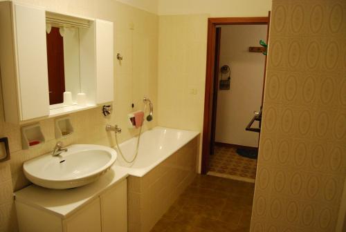 a bathroom with a white sink and a mirror at Appartamento Ilaria in Vermiglio