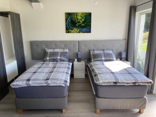 a bedroom with two beds and a picture on the wall at Kallenhard View Apartments in Adenau