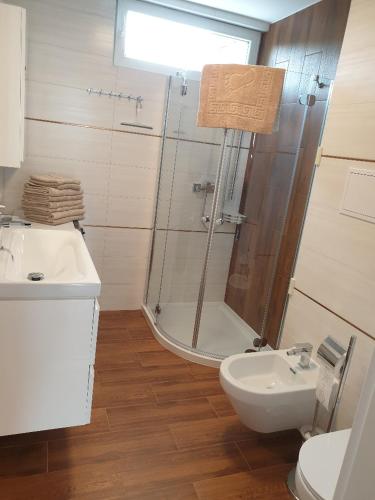 een badkamer met een douche, een toilet en een wastafel bij 13 Sopot in Sopot