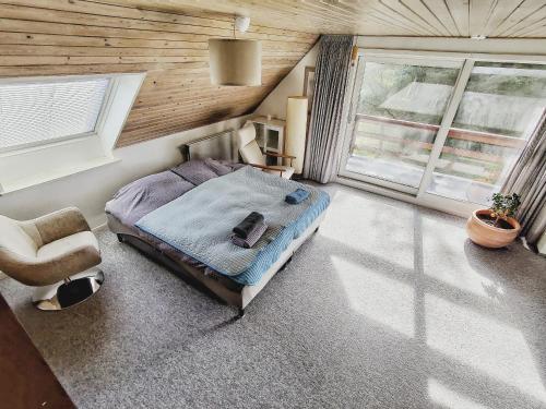 1 dormitorio con 1 cama, 1 silla y ventanas en Villa Nida en Ranum