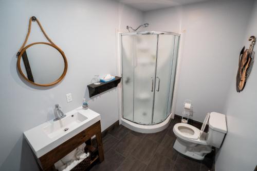 a bathroom with a shower and a toilet and a sink at Auberge du Vieux Faubourg in Sainte-Anne-des-Monts