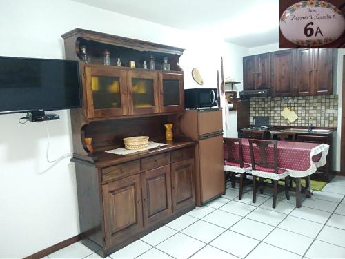 a kitchen with a refrigerator and a table and chairs at Fam Pisconti App 6A Camigliatello in Camigliatello Silano