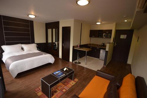 a bedroom with a bed and a living room at qp Hotels Lima in Lima