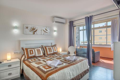 a bedroom with a bed and a large window at Sweet Holiday Place - Benalmadena Costa in Benalmádena