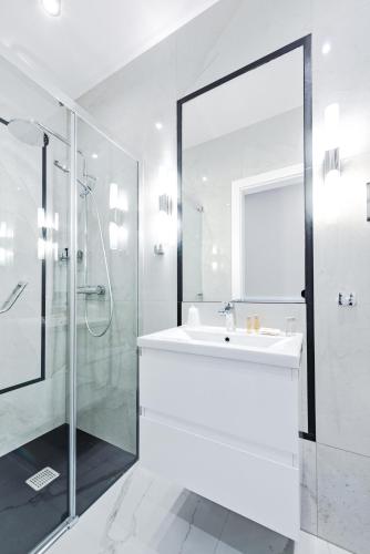 a white bathroom with a sink and a shower at Villa Hoff Wellness & Spa in Trzęsacz
