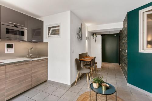 une cuisine avec une table et une salle à manger dans l'établissement Coeur Urbain Apartments - Place de la Comédie, à Montpellier