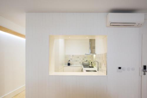 a white kitchen with a sink and a mirror at São Vicente 1797 Apartments in Lisbon