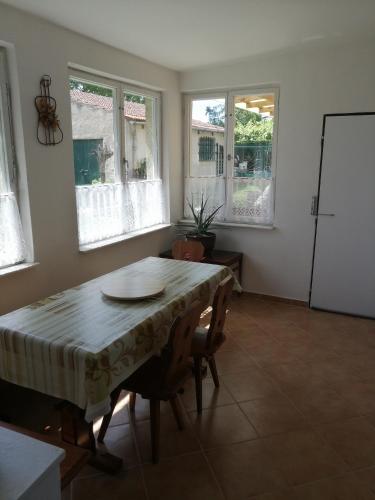 a dining room with a table and chairs and windows at U Ladi in Bulhary