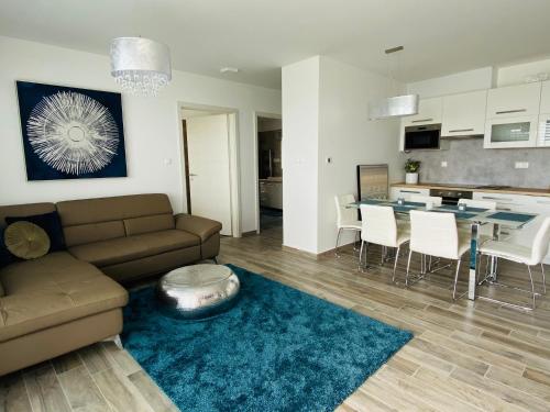 a living room and kitchen with a couch and a table at Royal Blue - luxurious flat with 5-star view over Lake Balaton in Keszthely