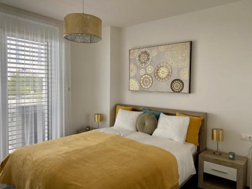 1 dormitorio con 1 cama y una pintura en la pared en Royal Blue - luxurious flat with 5-star view over Lake Balaton, en Keszthely