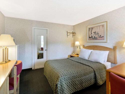Habitación de hotel con cama, mesa y puerta en POCONO NIGHT LODGE, en Bartonsville