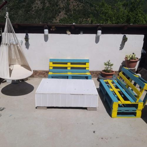 two blue and yellow chairs and a hammock on a patio at Casa Raul in (( Coramnic ))