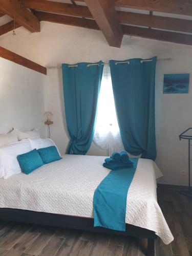 een slaapkamer met een groot bed en blauwe gordijnen bij A Teppa in Luri