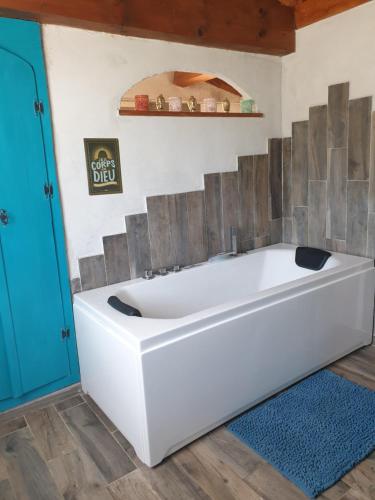 a white bath tub in a bathroom with a blue door at A Teppa in Luri