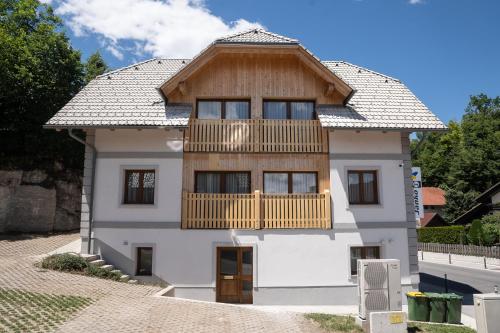 una casa con un balcón de madera en la parte superior en Apartments Janko, en Bled