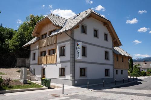 un grande edificio bianco con tetto in legno di Apartments Janko a Bled