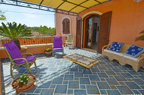 d'une terrasse avec des chaises violettes et un canapé. dans l'établissement Casa Spano 2 - RosariaVacanze, à Patù